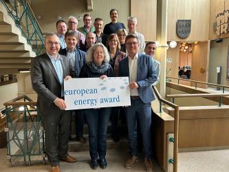 Vertreter der Stadtverwaltung Bretten halten die Auszeichnung "European Energy Award" in den Händen