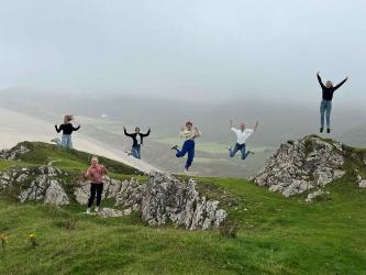 Jugendliche springen beim Rhossilli Beach in die Luft