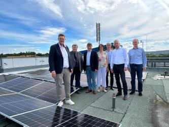 Vertreter vor PV-Anlagen auf Dach der Max-Planck-Realschule